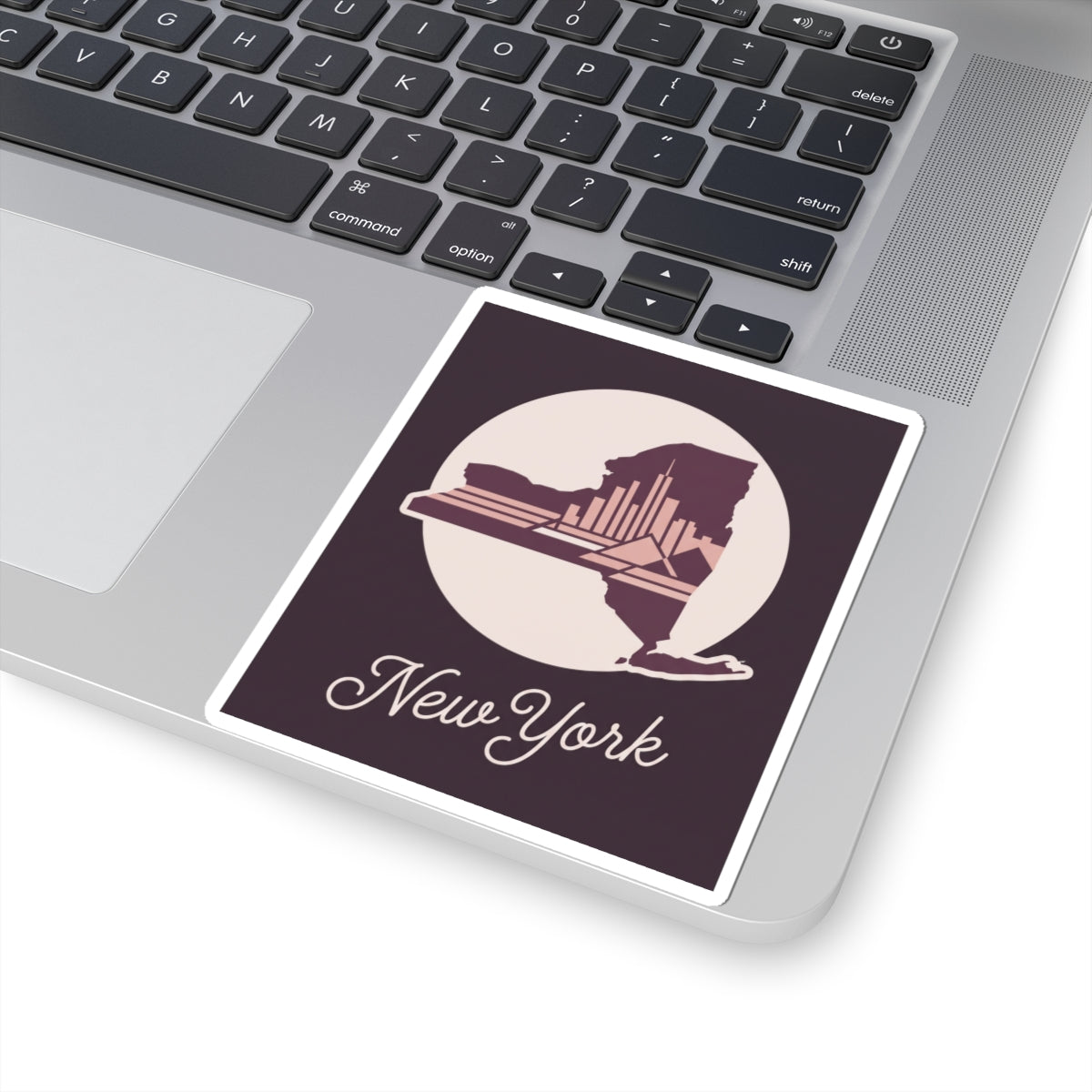 New York skyline decal sticker on laptop screen area, with circular state silhouette and cursive “New York”.