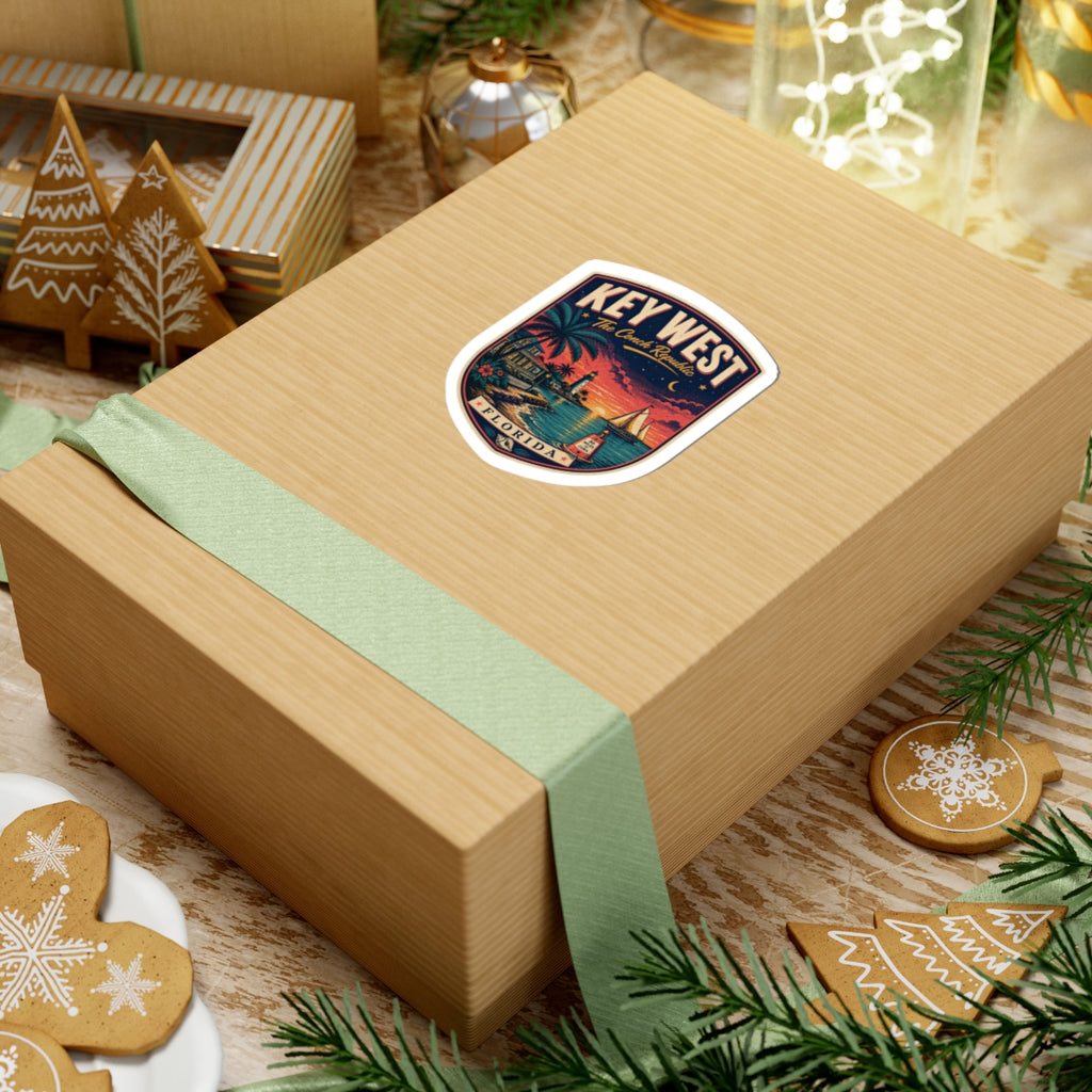 Key West luggage tag sticker on a wrapped gift box, shield design with palm sunset harbor