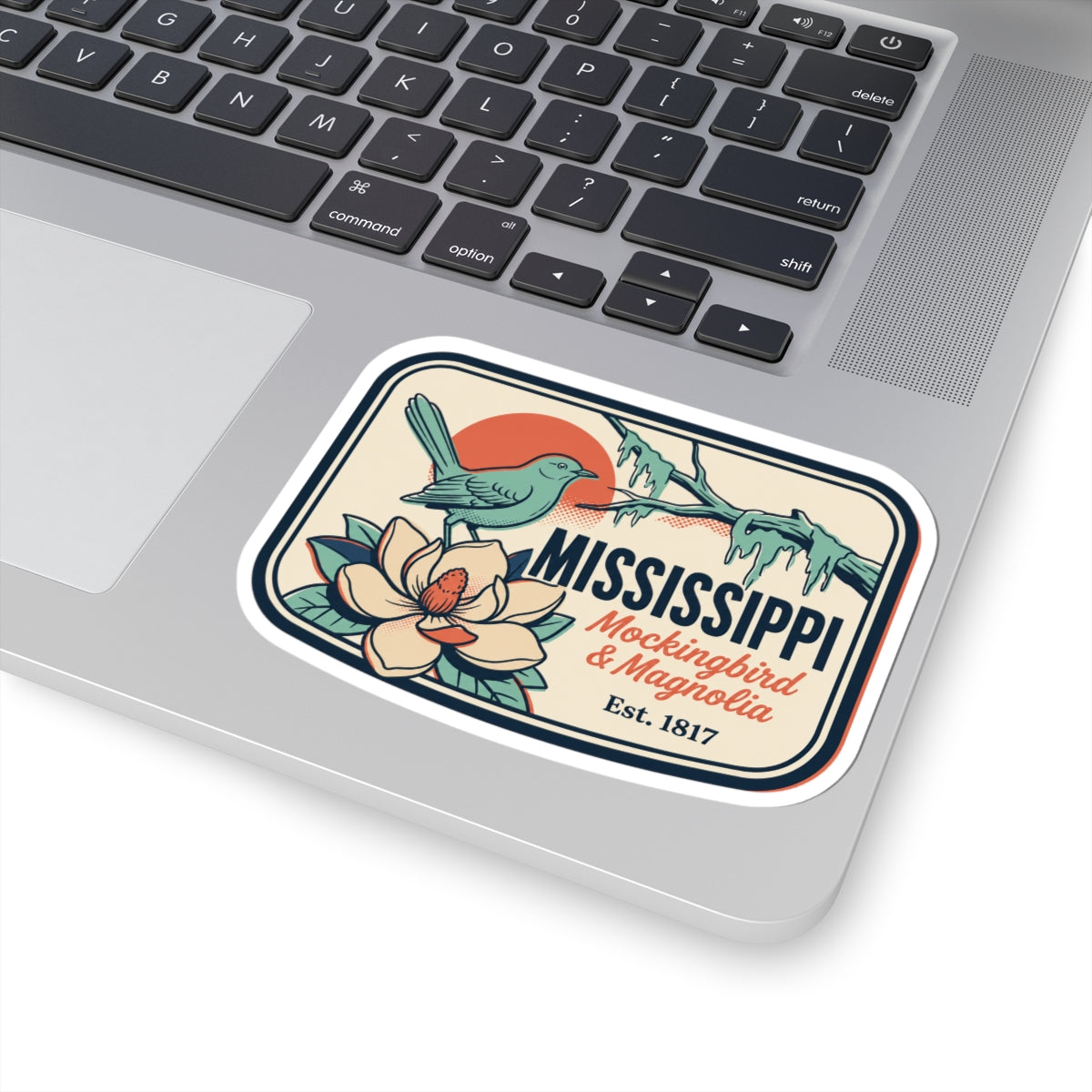 Mississippi state vinyl sticker on laptop, teal mockingbird and magnolia badge design
