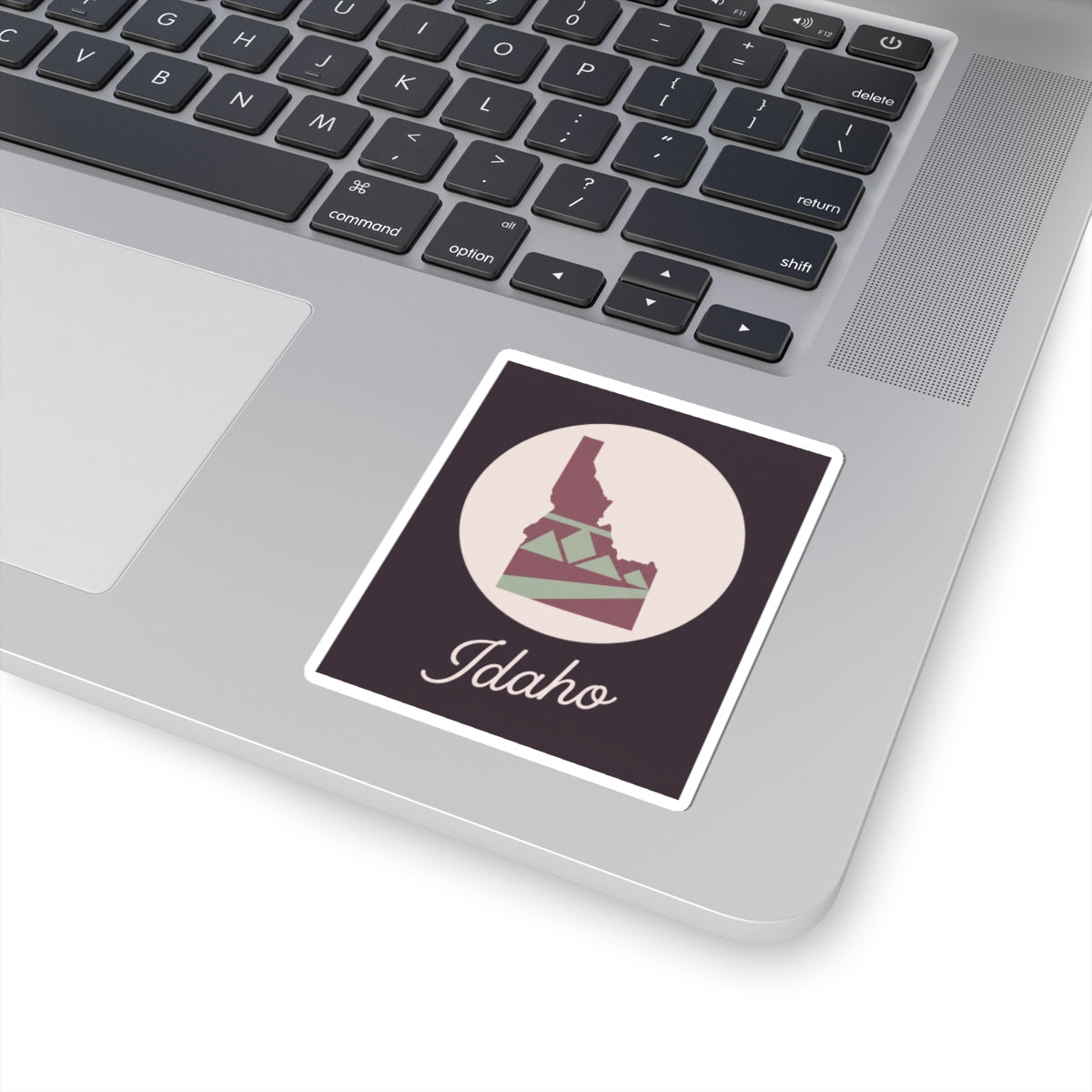 Idaho state silhouette sticker on a dark mauve square with white kiss-cut border