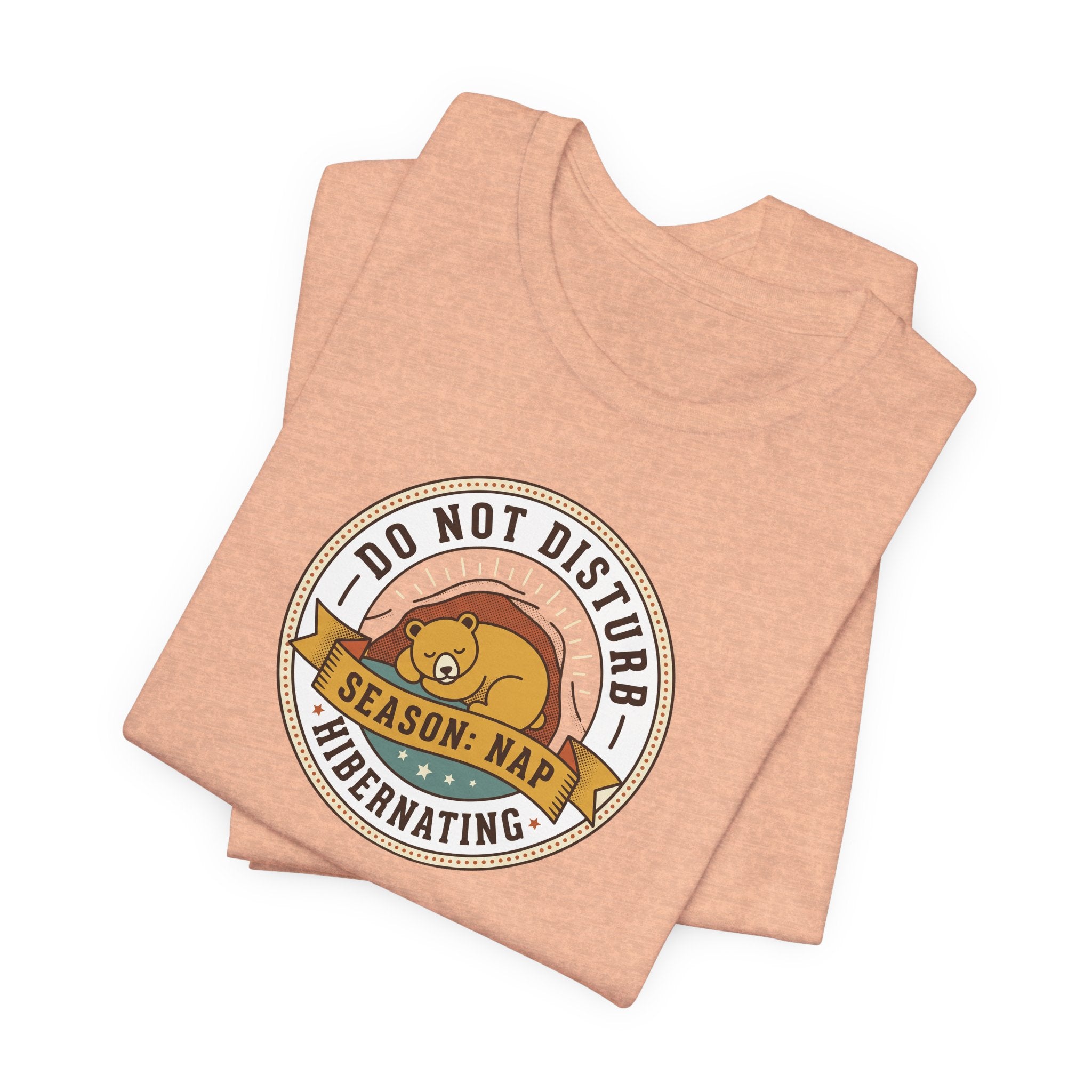 Peach T-shirt with round bear sleeping badge graphic on chest