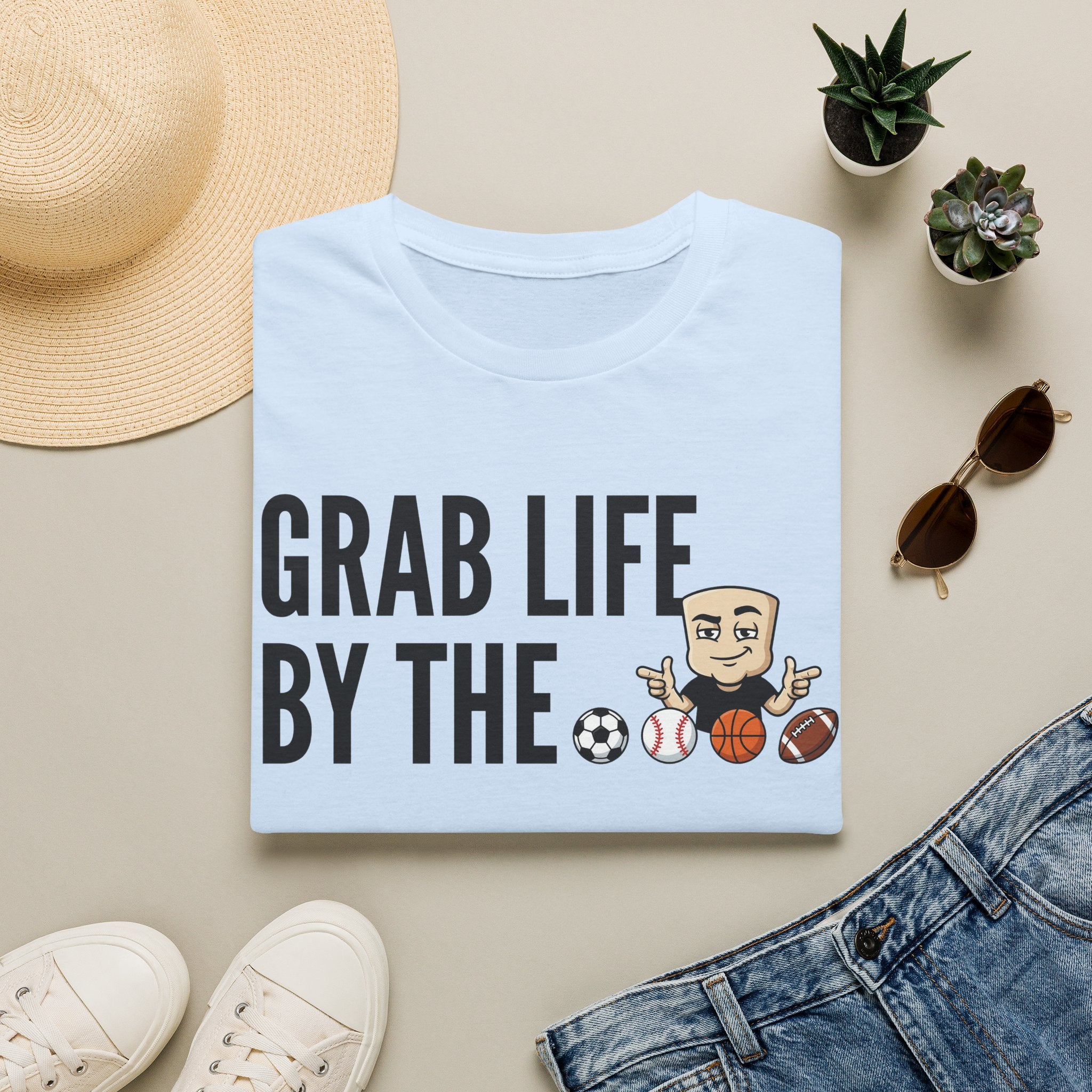 Light blue T-shirt with “GRAB LIFE BY THE” sports ball graphic and cartoon coach