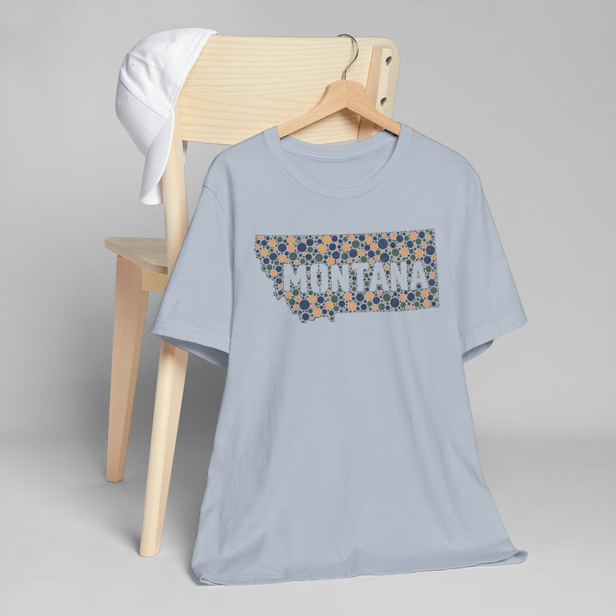 Light blue crew-neck t-shirt with colorful Montana map graphic and dot pattern.