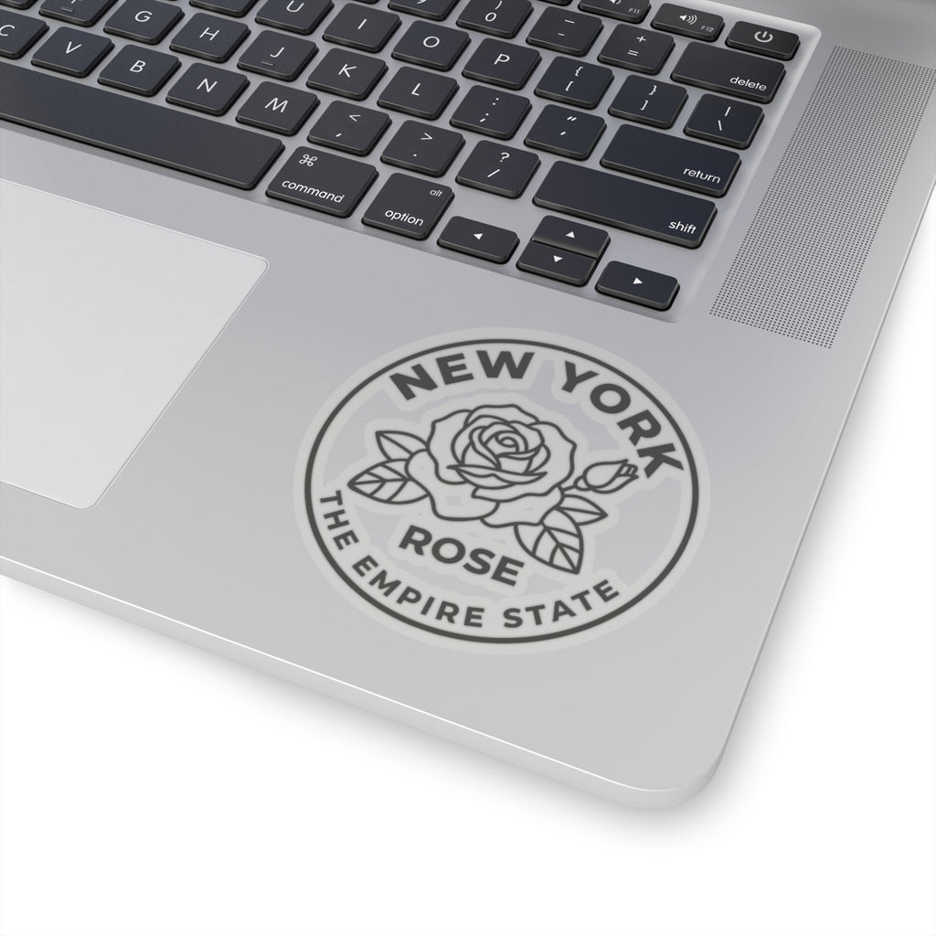 Circular rose state sticker on laptop showing “NEW YORK” and “THE EMPIRE STATE”