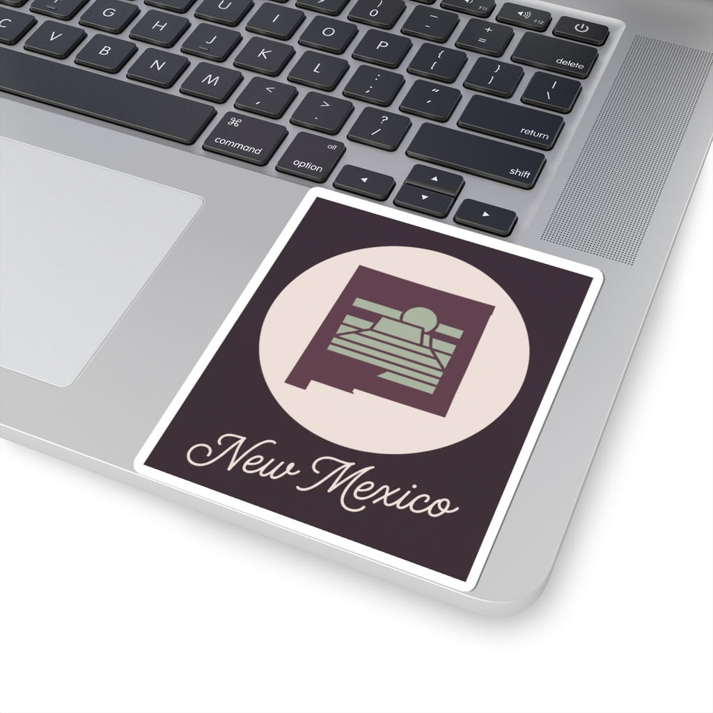 New Mexico sticker decal on laptop showing circular desert mesa sunrise and “New Mexico” text