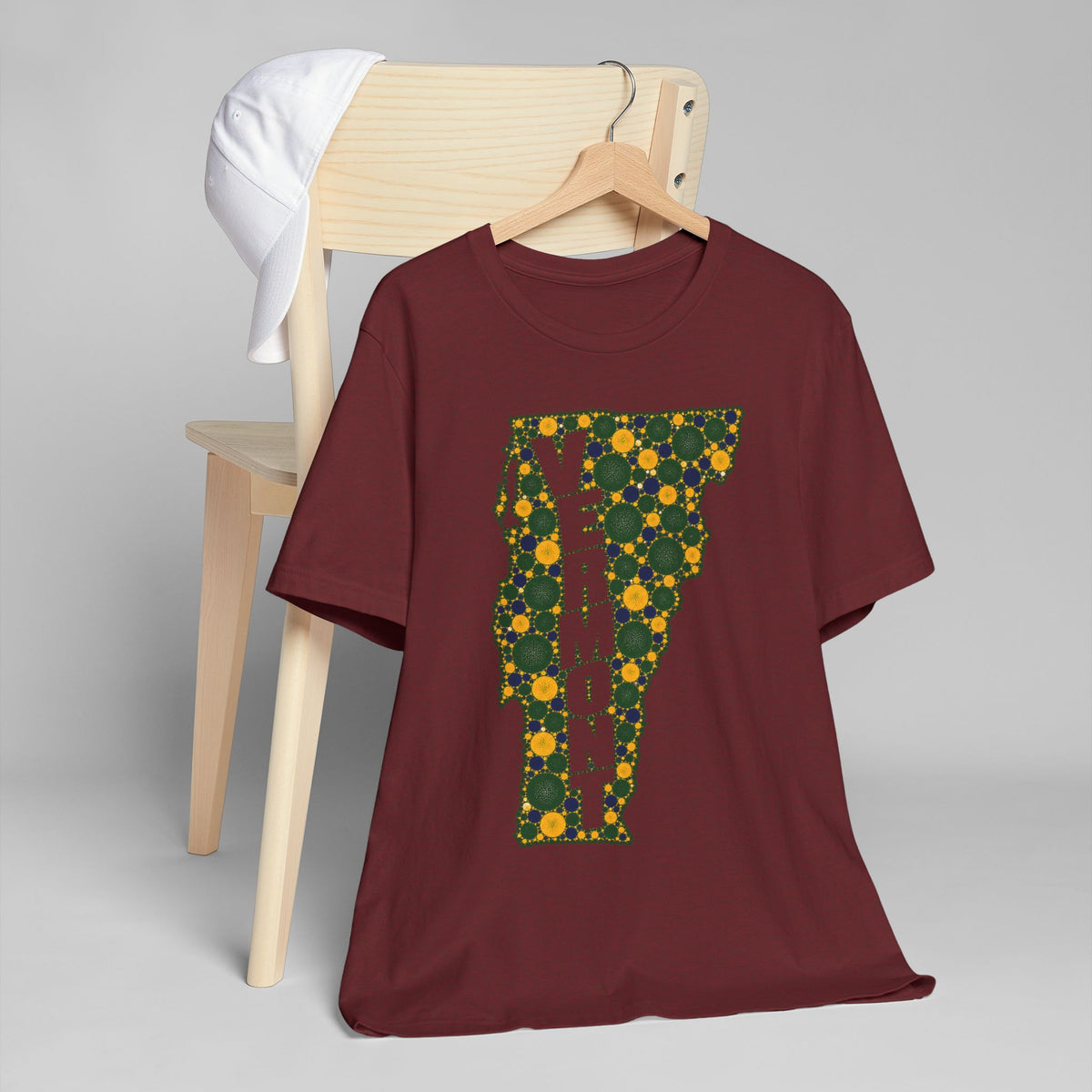 Burgundy T-shirt with green and gold floral map letter graphic