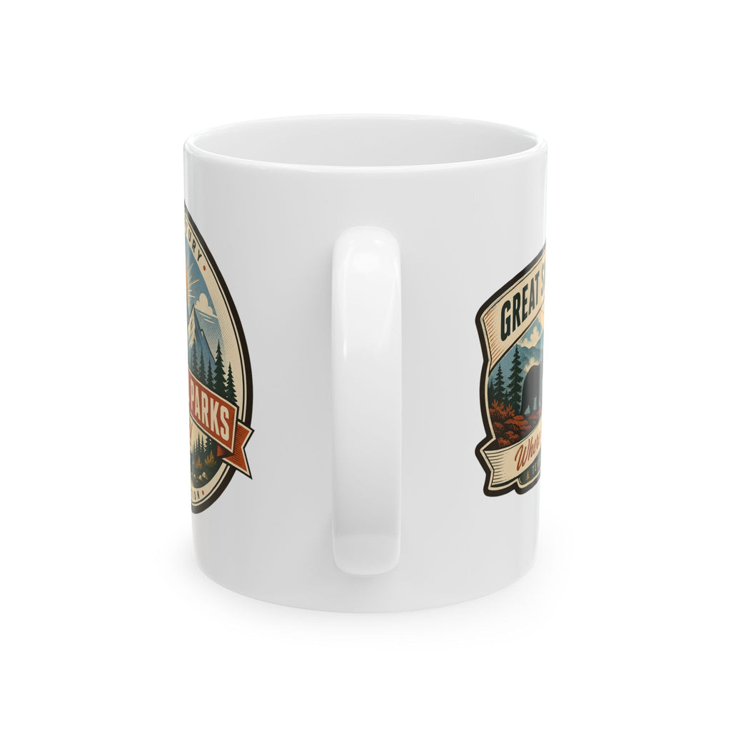 White ceramic travel mug with central handle, two side badges with mountain scenes