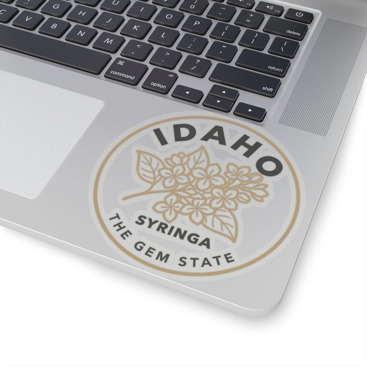 Transparent vinyl sticker on laptop: Idaho syringa floral emblem with "the gem state"