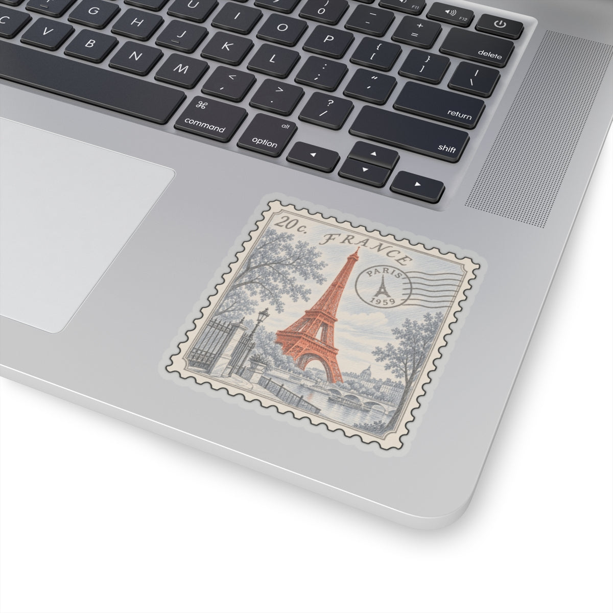 France postage stamp sticker with Eiffel Tower, gray-blue scene, white kiss-cut border on laptop