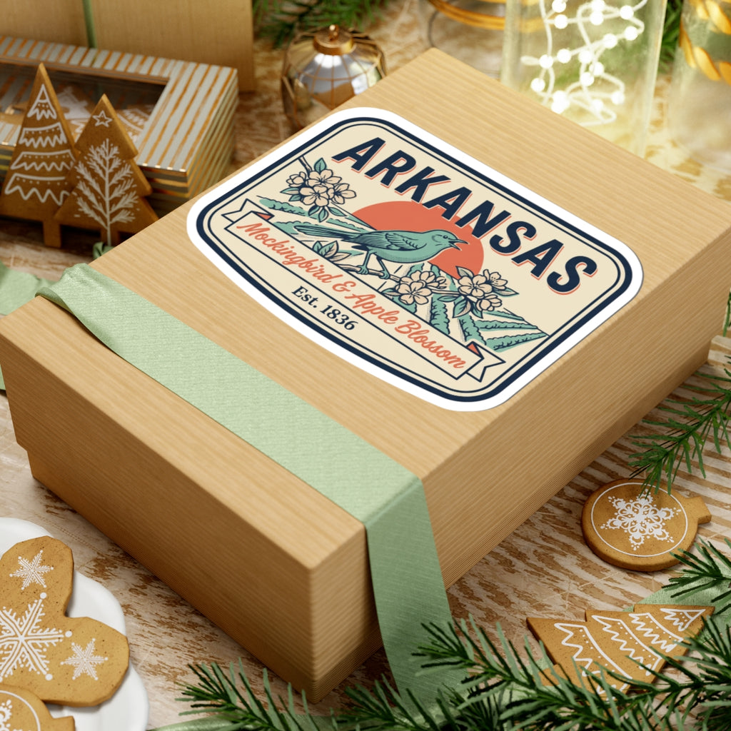 Arkansas state badge sticker on a gift box lid, blue mockingbird and apple blossom art