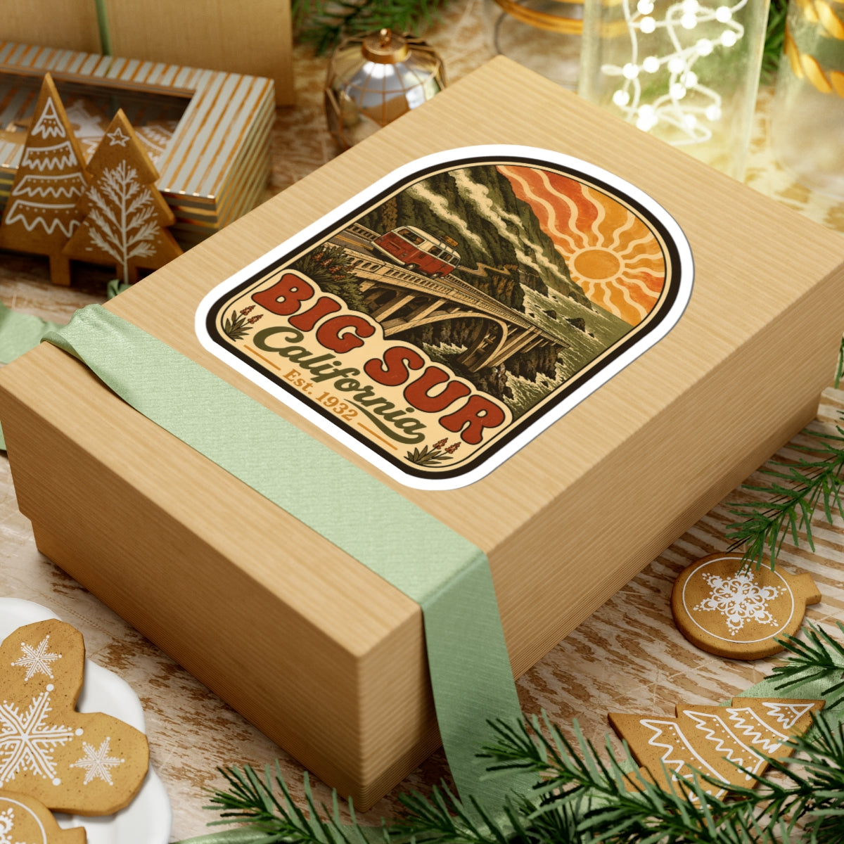 Kiss-cut Big Sur California sticker on wrapped gift box, vintage coastal bridge with sun and van.