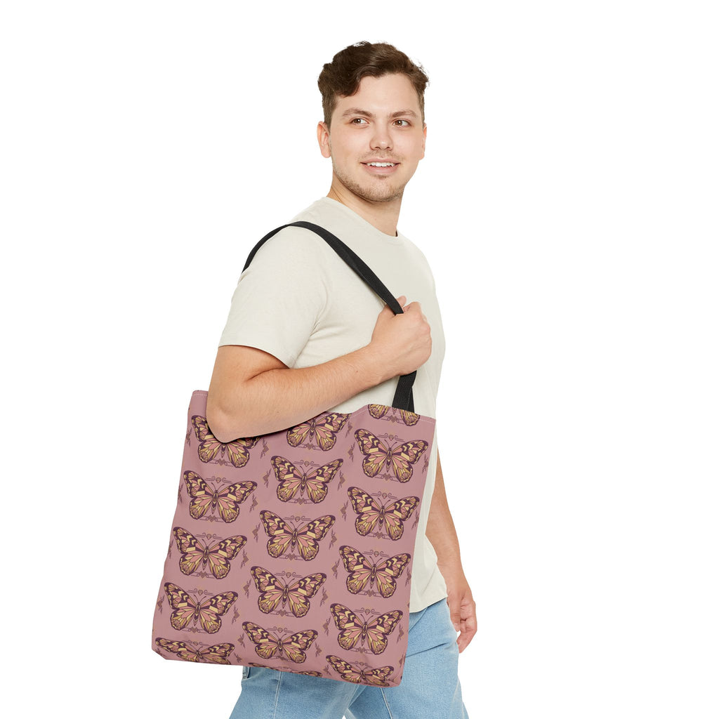Pink butterfly print tote bag with black straps worn across the shoulder