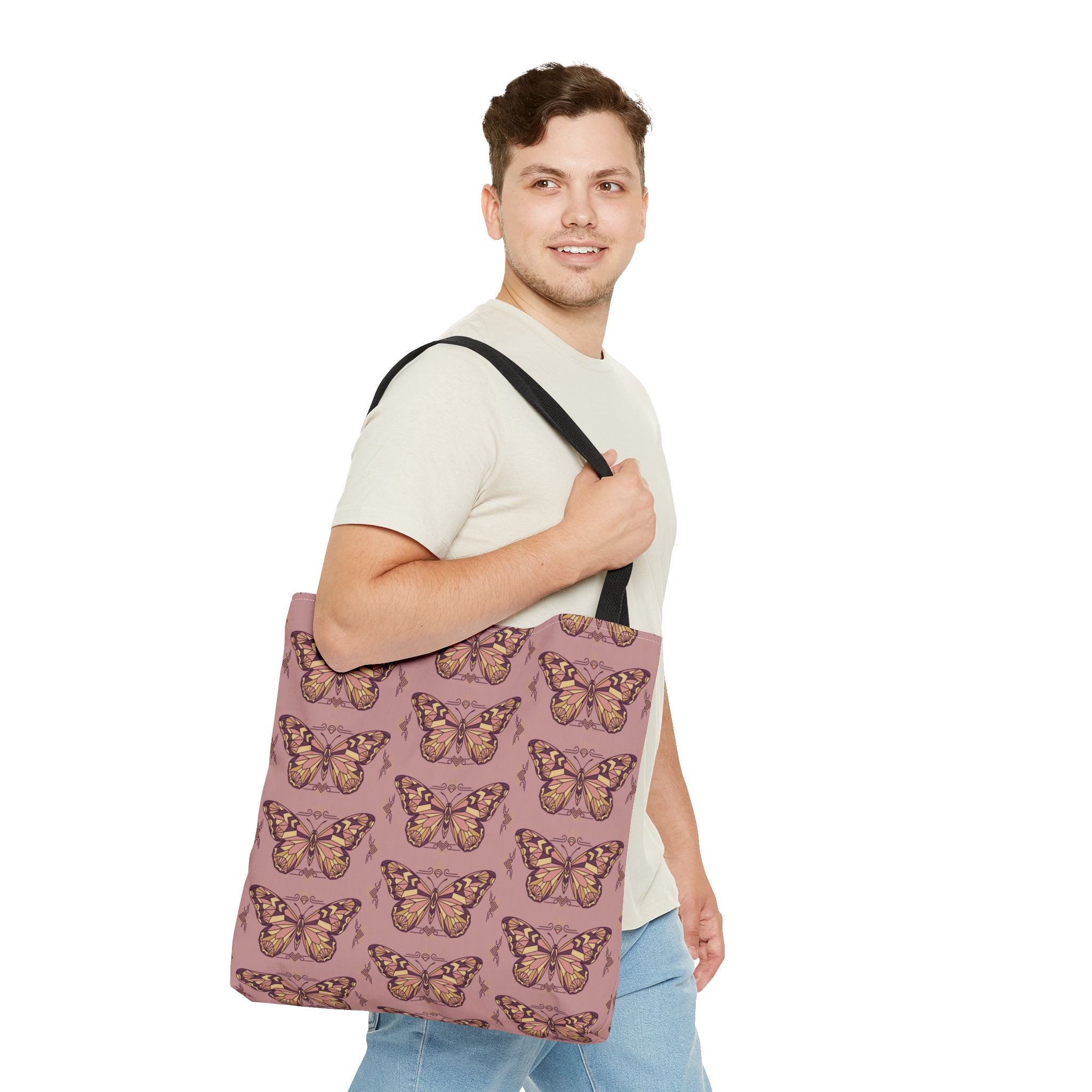 Pink butterfly print tote bag with black straps worn across the shoulder