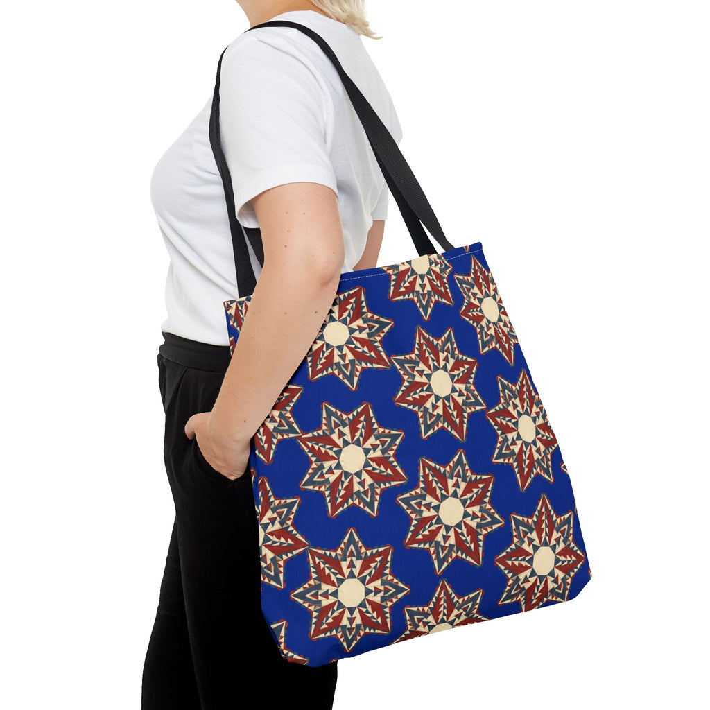 Blue tote bag with starburst floral pattern and black shoulder straps, side view