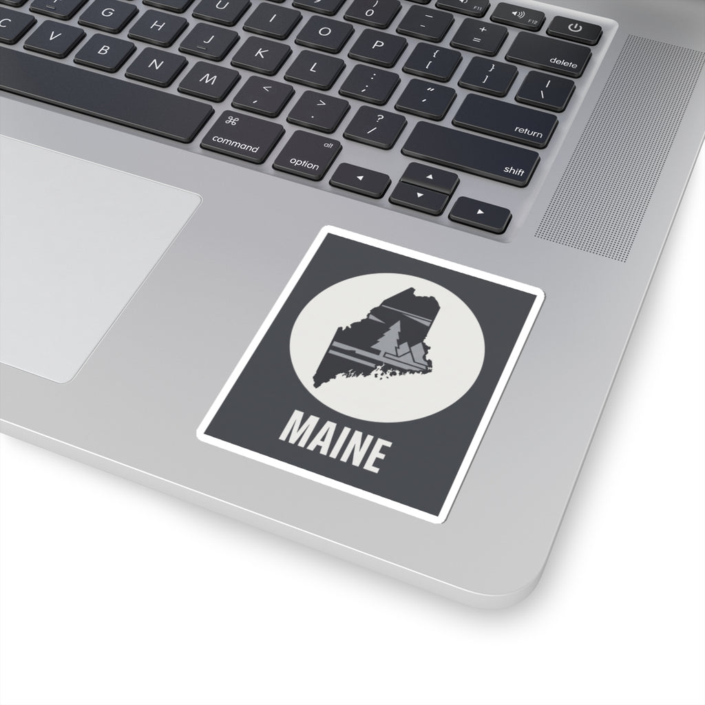 Rectangular Maine silhouette sticker on a backing sheet, circular pine tree map and 'MAINE'.