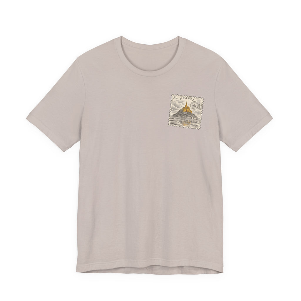Light beige T-shirt with small vintage postage stamp graphic on left chest.