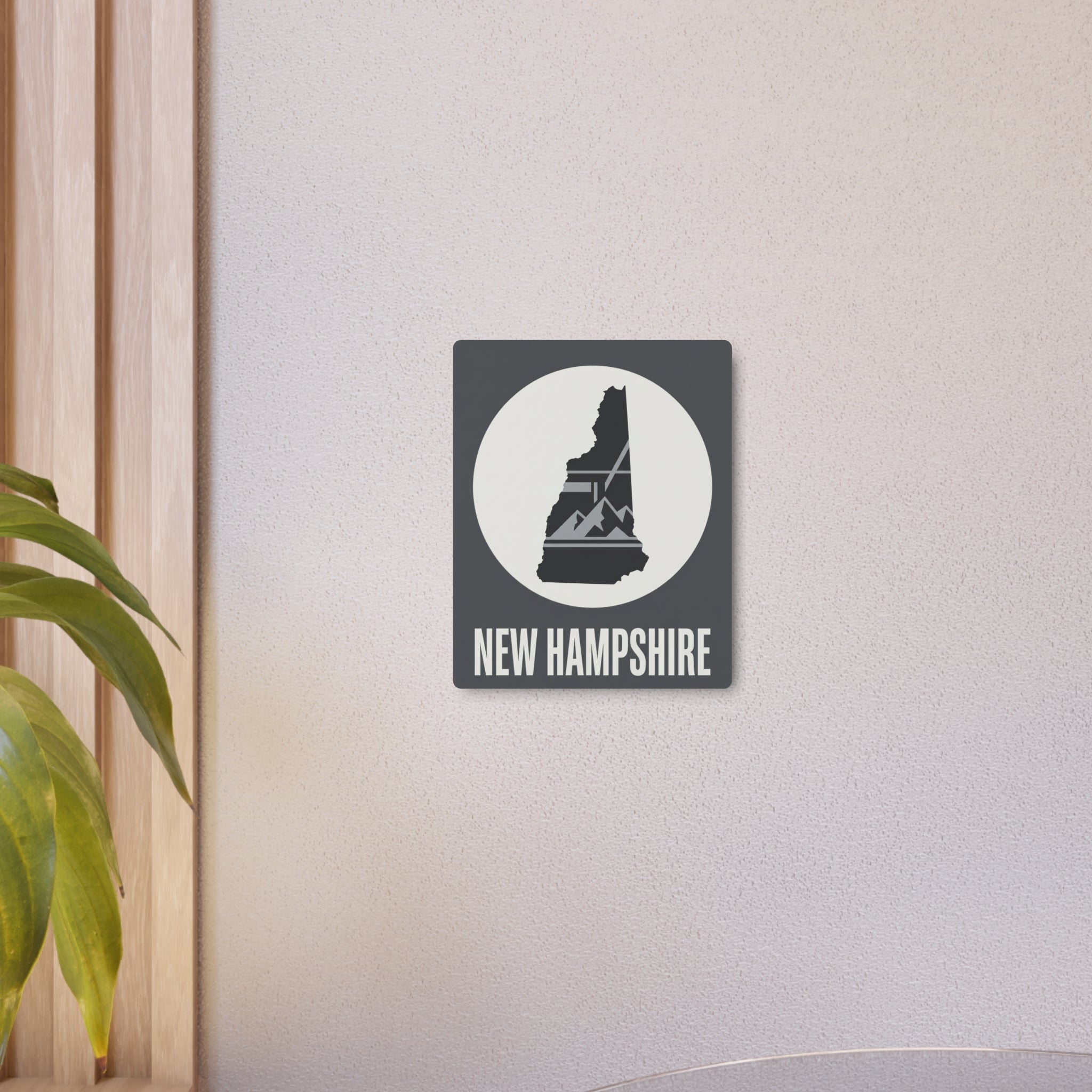 Metal wall art sign mounted on wall with New Hampshire silhouette and "NEW HAMPSHIRE" text