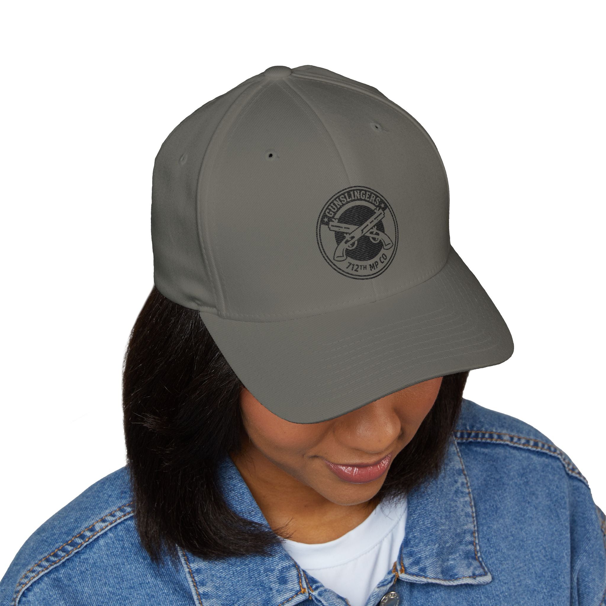 Gray embroidered baseball cap with round black emblem on front