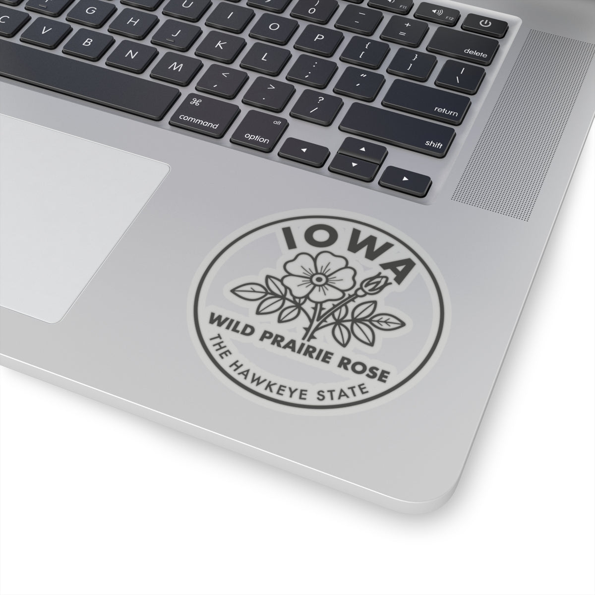 Circular vinyl decal on laptop lid featuring Iowa and wild prairie rose flower