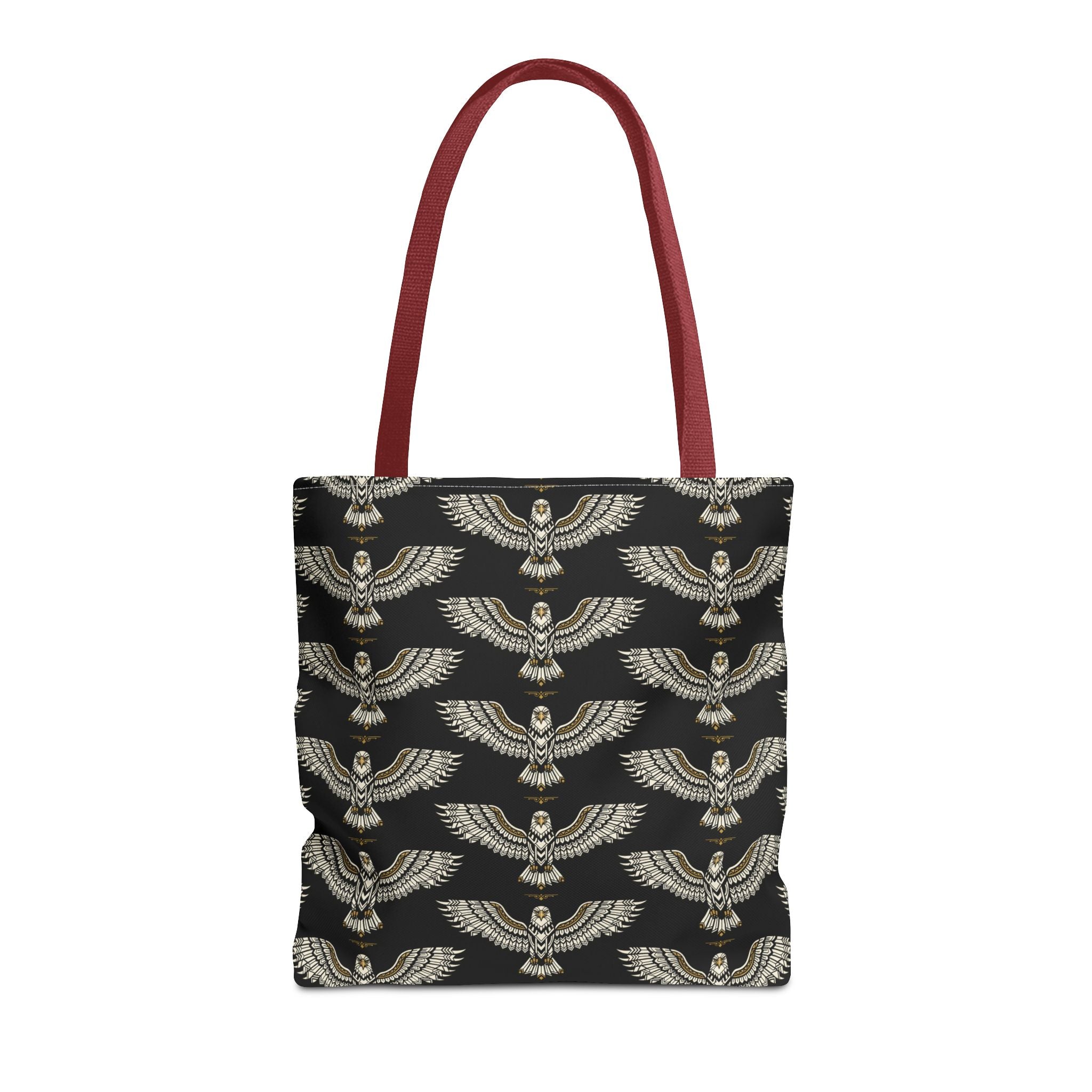Tote bag with black fabric and repeating gold winged scarab pattern, red handles