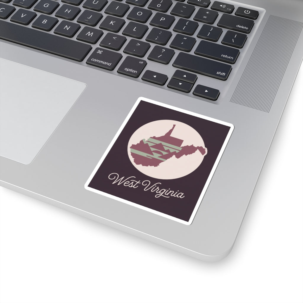 Square West Virginia decal on laptop keyboard: circular state graphic with “West Virginia” script.