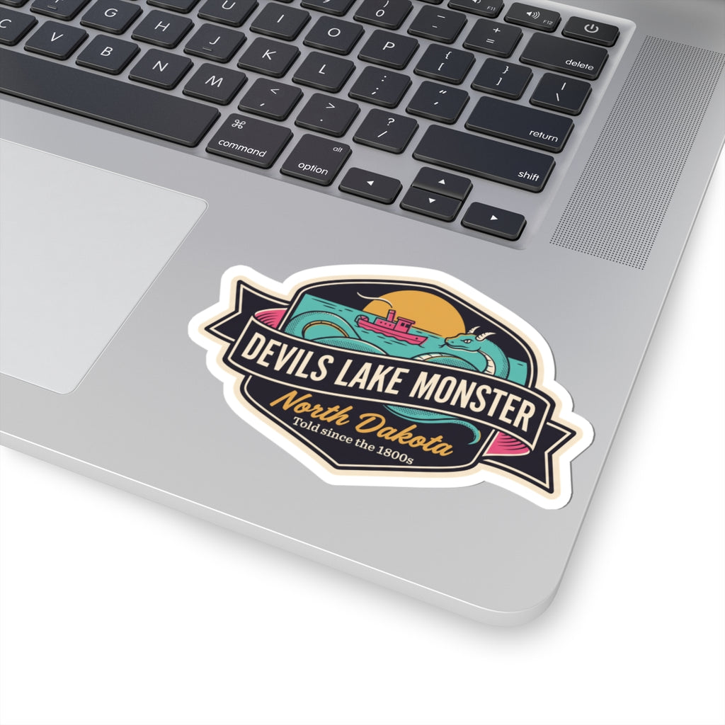 Kiss-cut sticker badge showing teal monster, ship, and “North Dakota” script