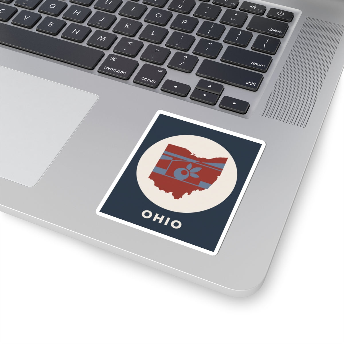 Ohio sticker on a laptop keyboard, square design with map, apple icon, and OHIO text
