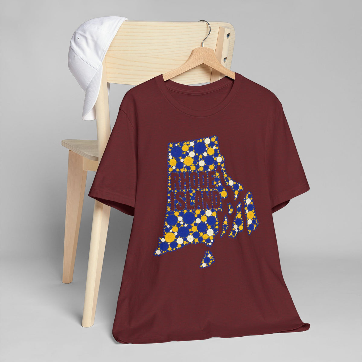 Burgundy t-shirt with multicolor polka dot Rhode Island outline graphic on front