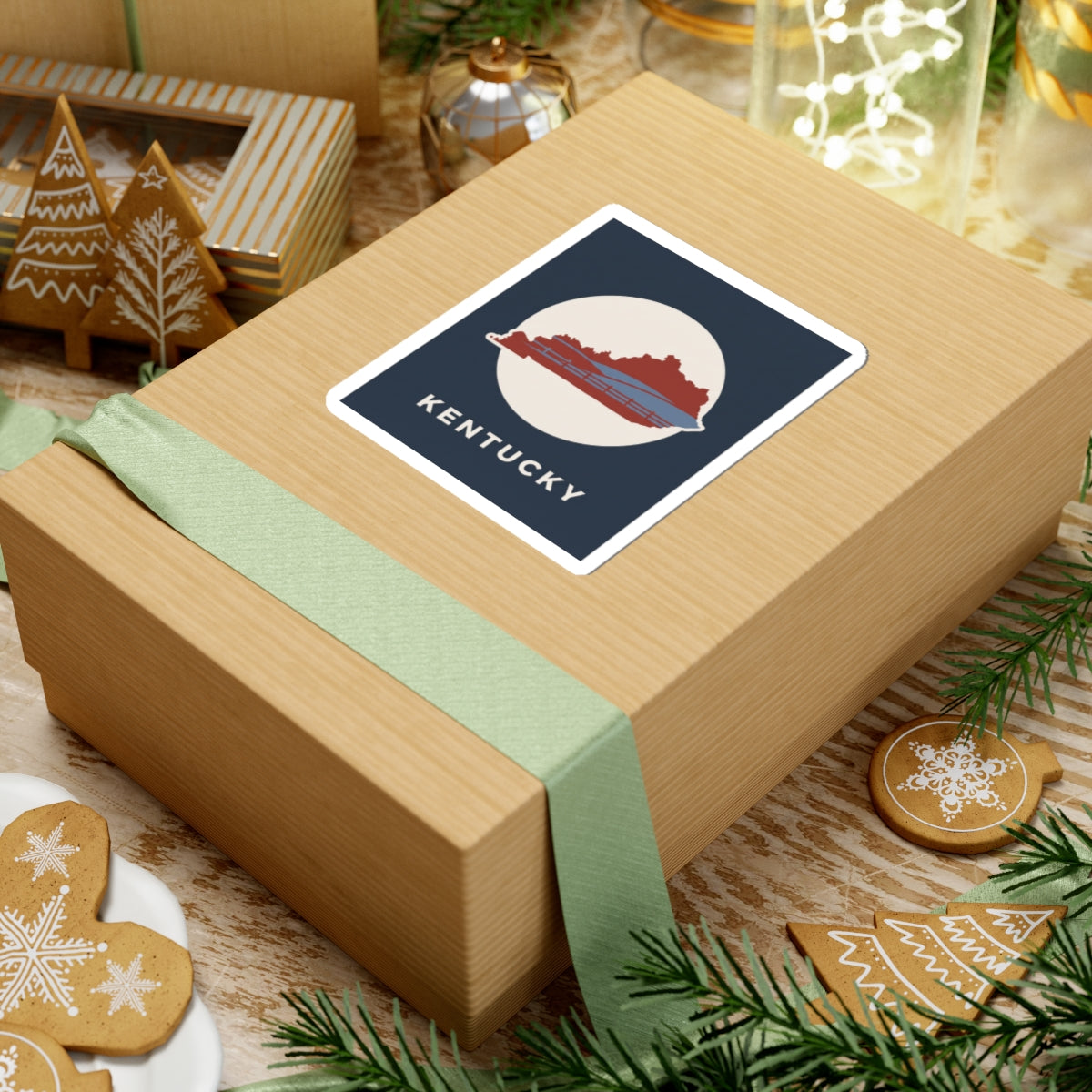 Kentucky travel decal sticker on wrapped gift: navy square with red Kentucky silhouette and KENTUCKY