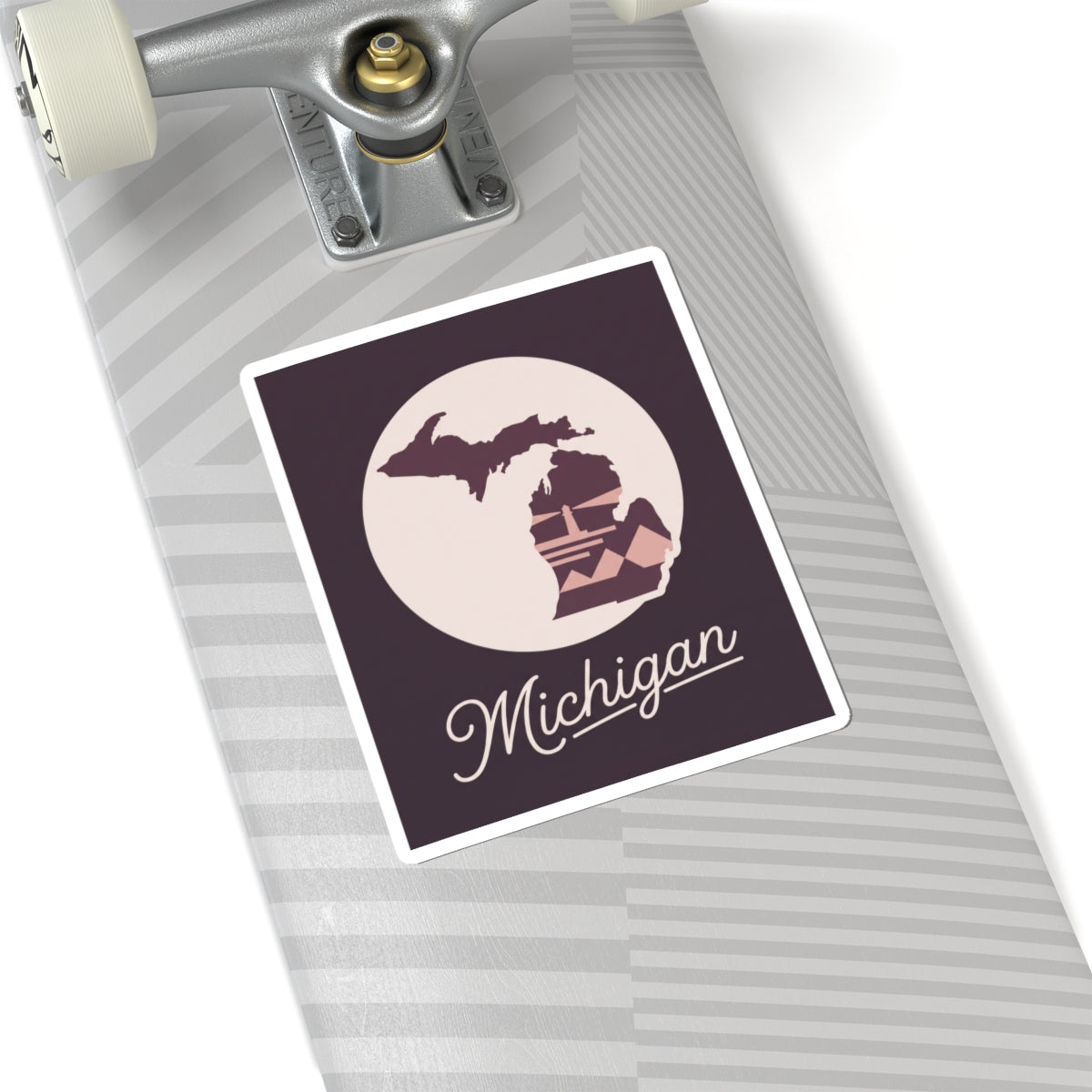 Square Michigan kiss-cut decal on a suitcase: purple state map and lighthouse with cursive “Michigan”.