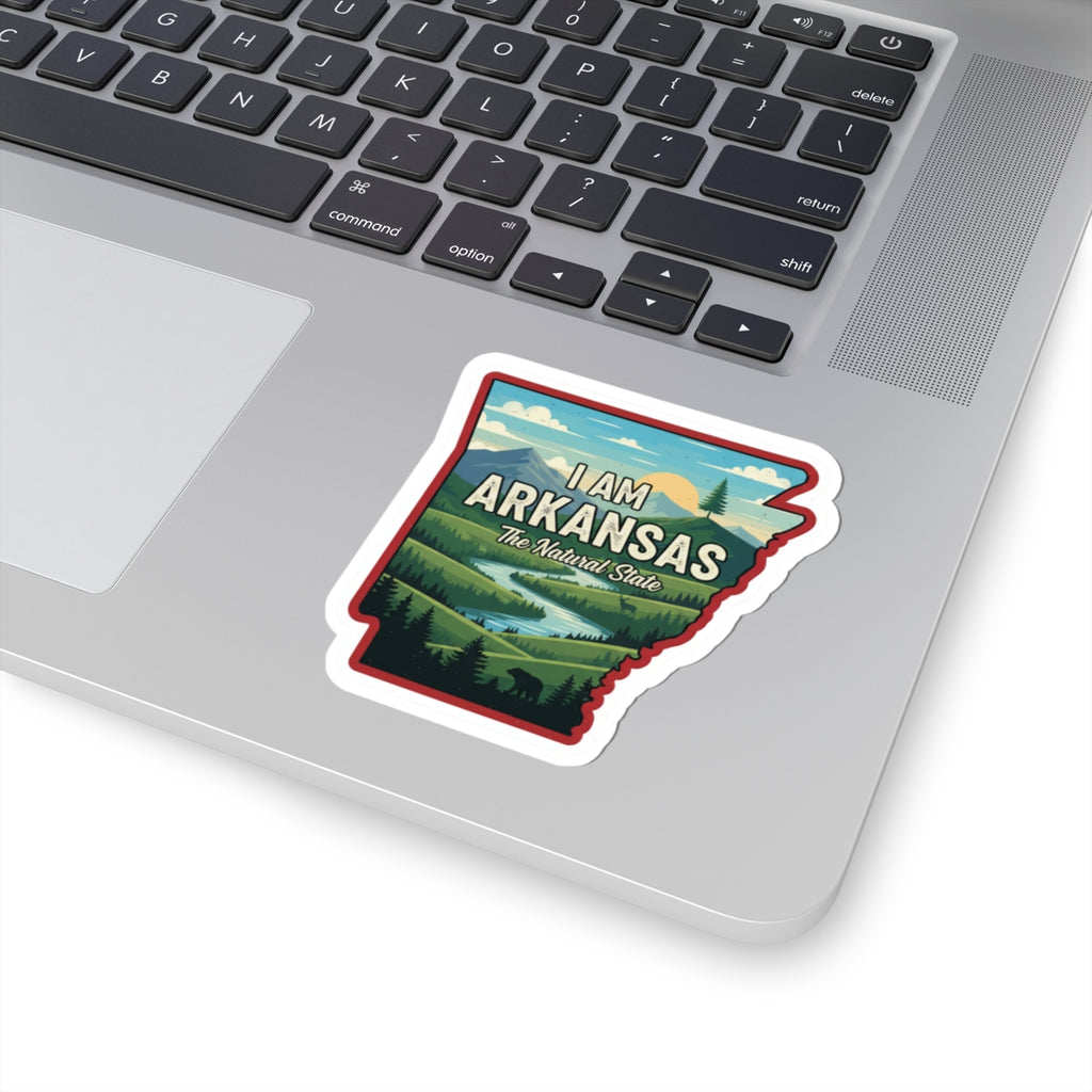 I AM ARKANSAS sticker on laptop keyboard, illustrated state outline with “The Natural State”