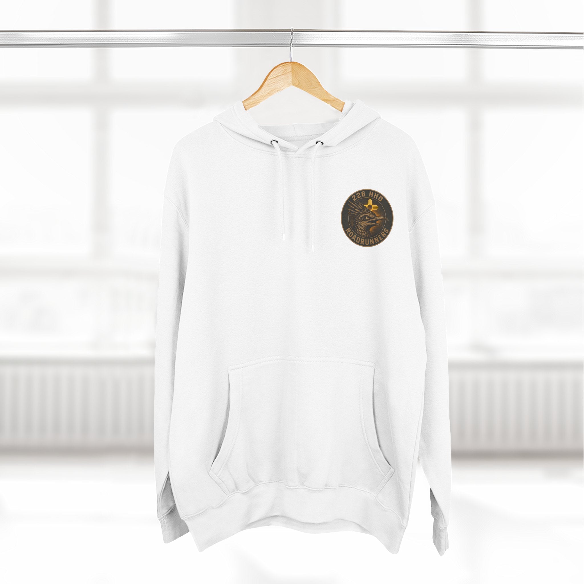 White pullover hoodie on hanger, hood and front pocket with chest patch