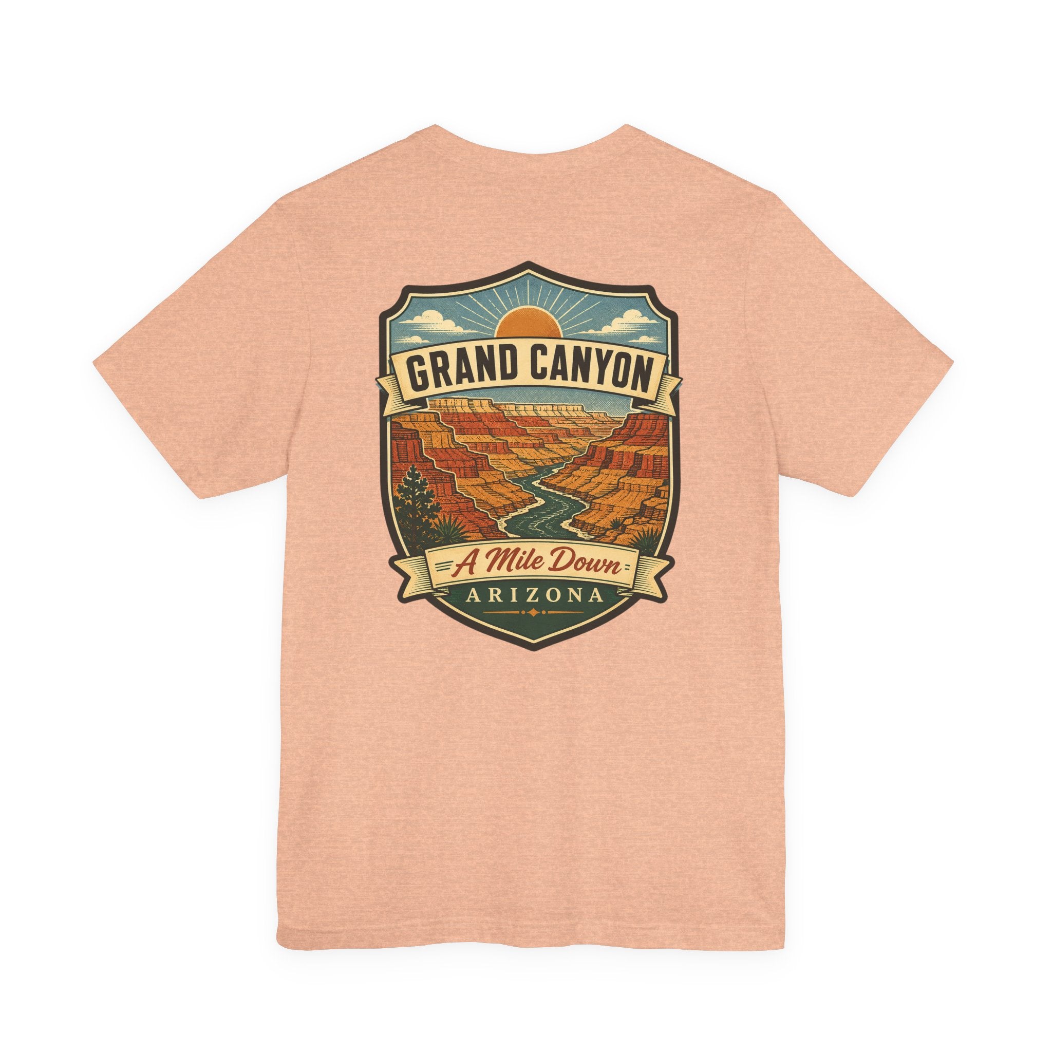 Light tan crew-neck T-shirt with large Grand Canyon scenic badge graphic reading "A Mile Down"