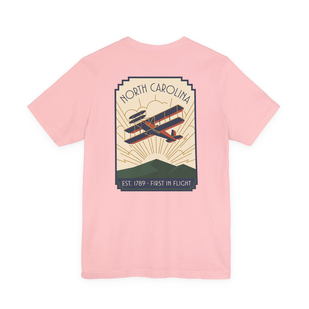 Light pink T-shirt with large North Carolina biplane graphic on the back