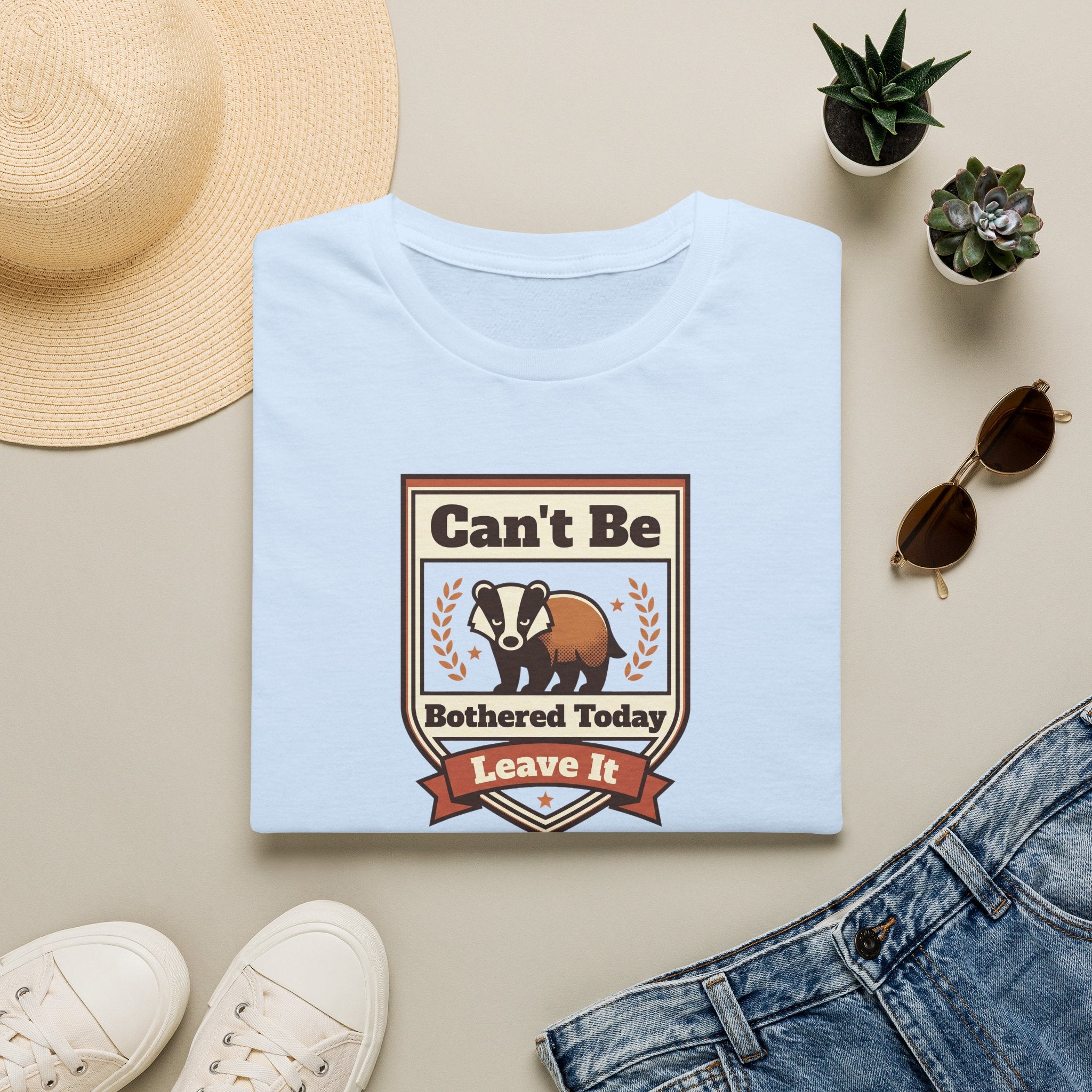 Light blue T-shirt with crew neck and brown skunk graphic with laurel and ribbon.