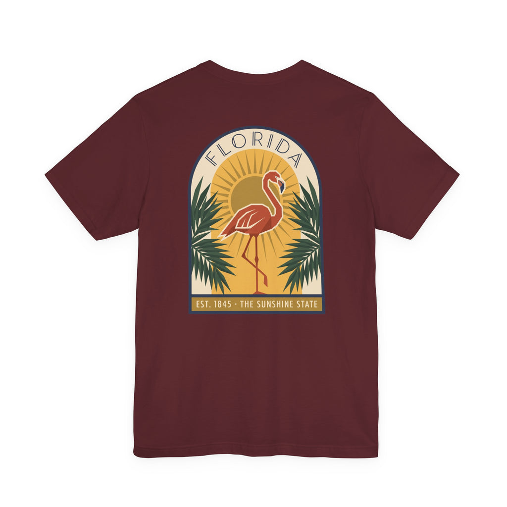 Maroon T-shirt with round flamingo logo and palm art deco graphic on chest