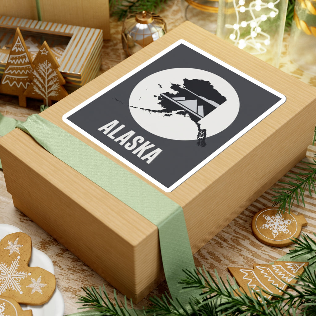 Square Alaska “ALASKA” text vinyl sticker on a wrapped gift box, dark gray and white.