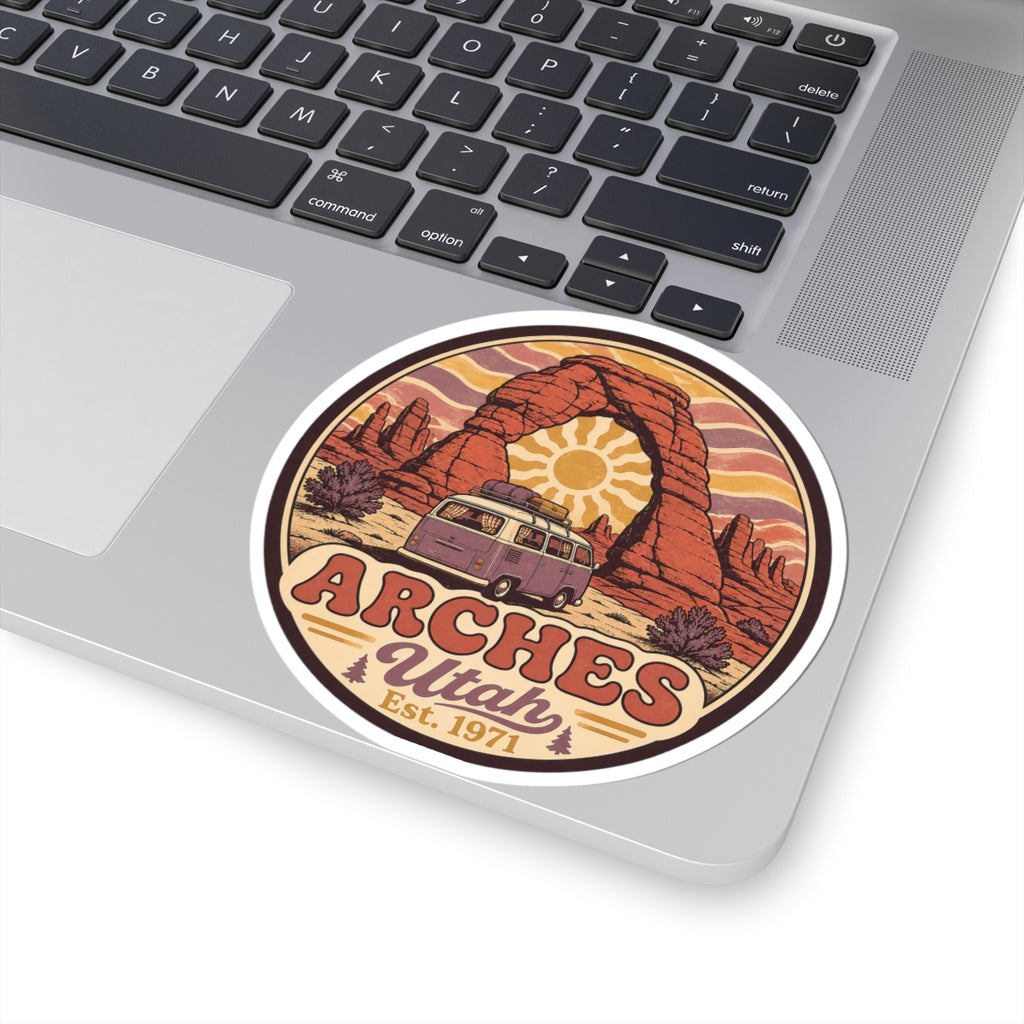 Round sticker with red rock arch, sunburst, camper van, and "ARCHES Utah Est. 1971"
