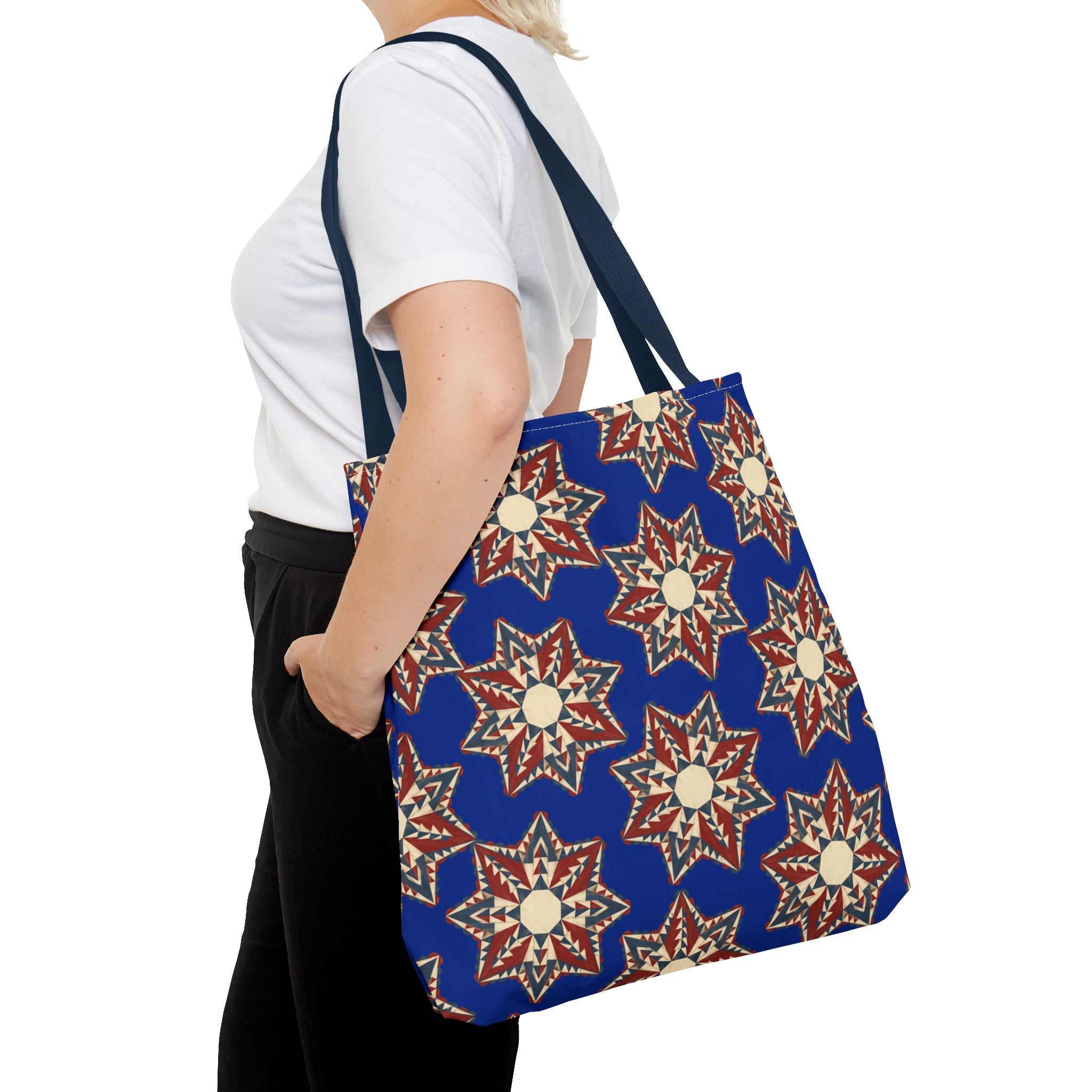 Navy tote bag with red and cream starburst floral pattern, long shoulder strap and handles.