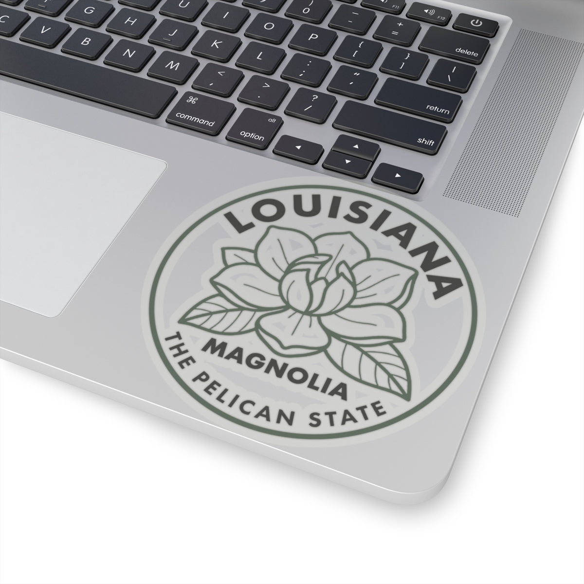 Transparent vinyl round Louisiana magnolia sticker on laptop lid, gray magnolia with pelican state