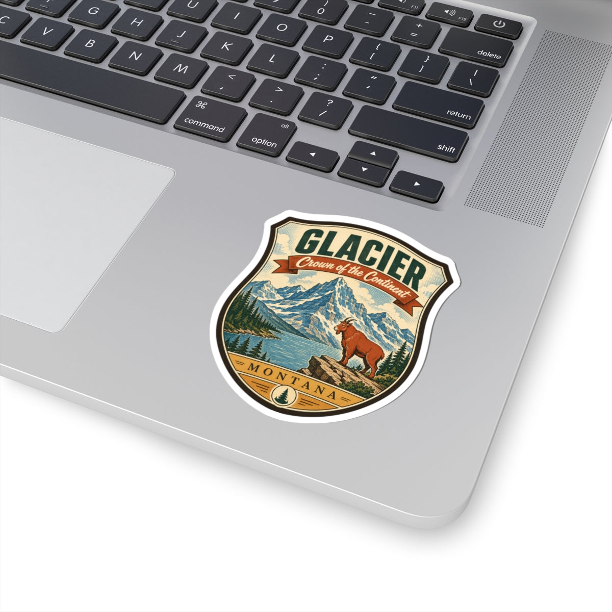 Small shield travel sticker with “GLACIER,” mountain scene, pine trees, brown dog, “MONTANA”