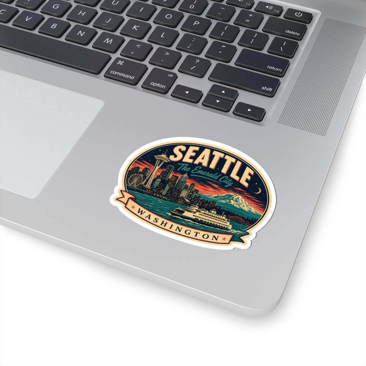 Seattle luggage tag sticker on a laptop trackpad, circular badge with skyline and Mount Rainier