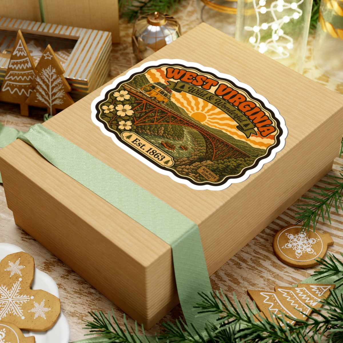 West Virginia kiss-cut sticker on a gift box, featuring bridge, sun, flowers, and Est. 1863.