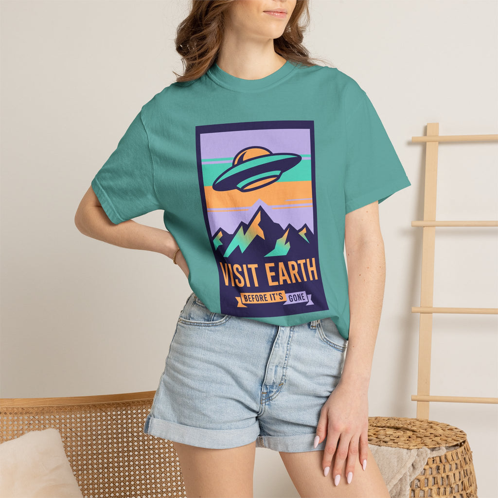 Teal T-shirt with square UFO poster graphic and 'VISIT EARTH' lettering.