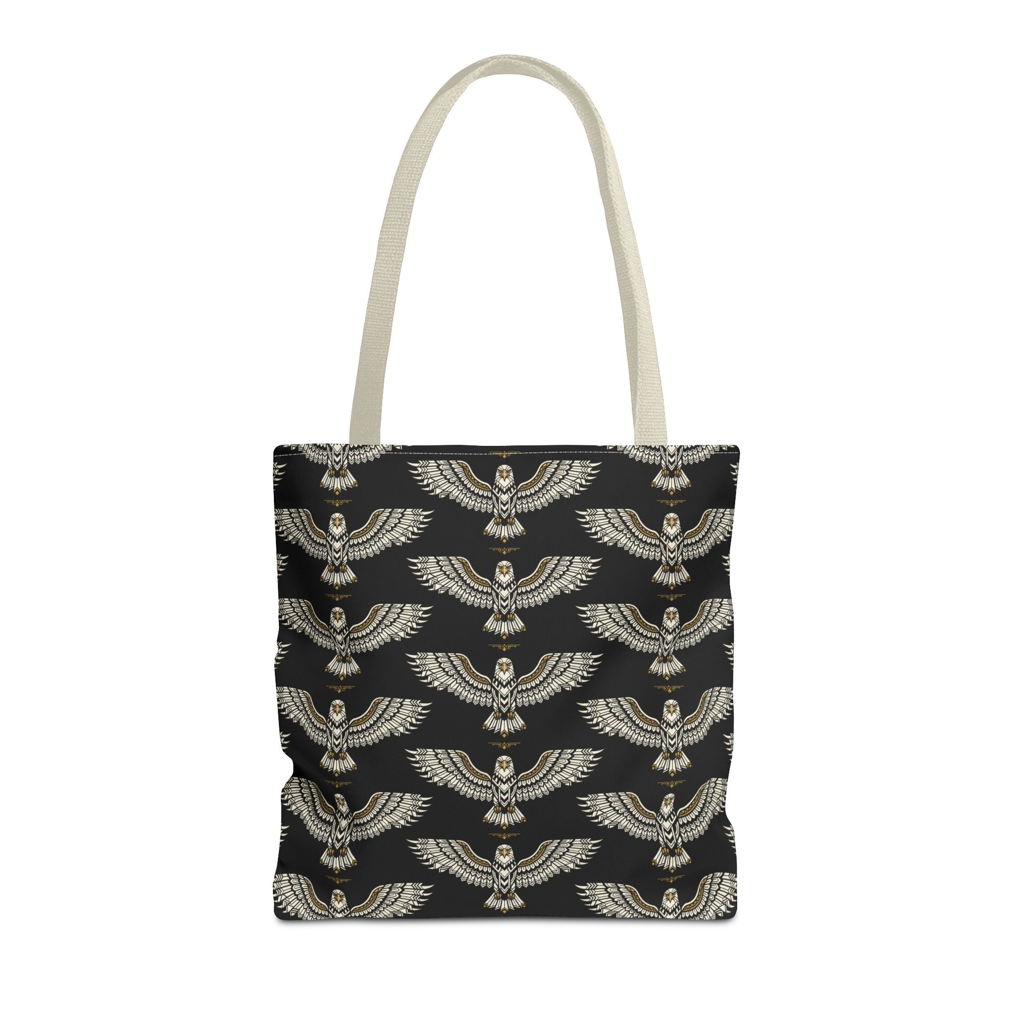 Tote bag featuring winged scarab pattern on black fabric, gold emblems, cream handles