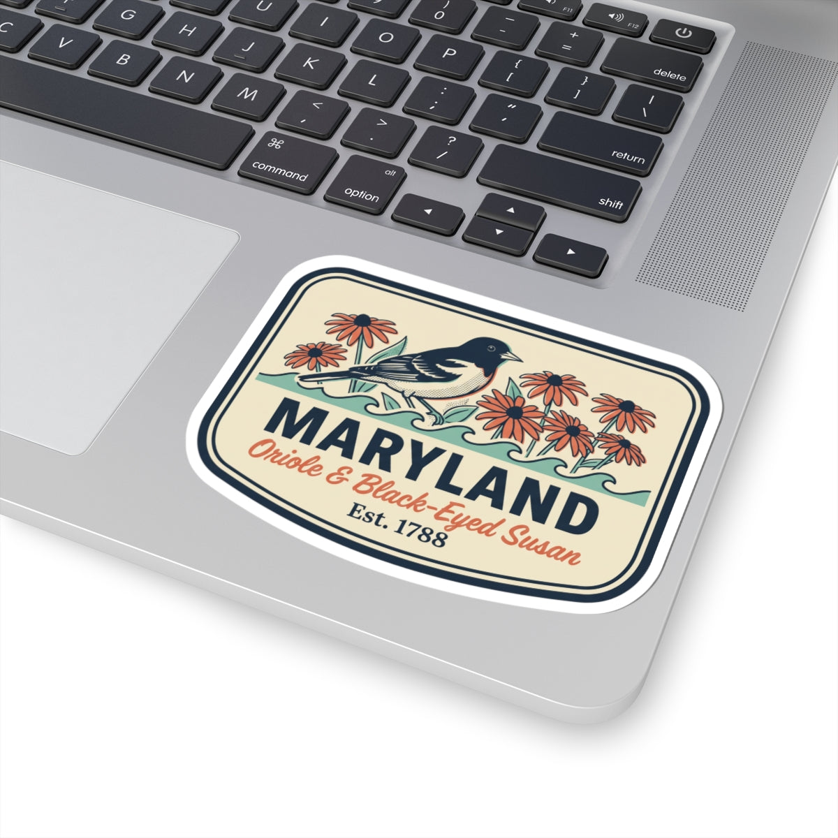 Maryland sticker placed on laptop, rounded badge with blue bird, orange flowers, and “Est. 1788”