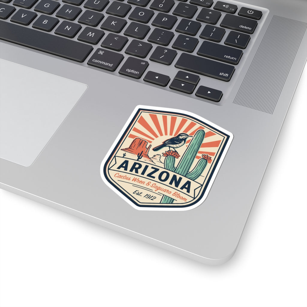 Arizona sticker badge on a laptop lid, cactus wren and saguaro bloom design, Est. 1912.