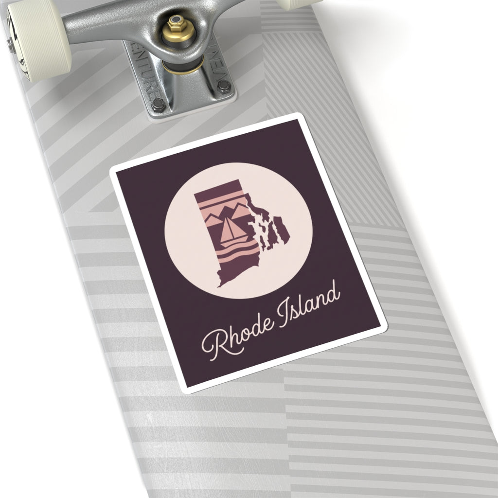 Rhode Island sticker on a laptop trackpad area, circular lighthouse emblem with 'Rhode Island' script