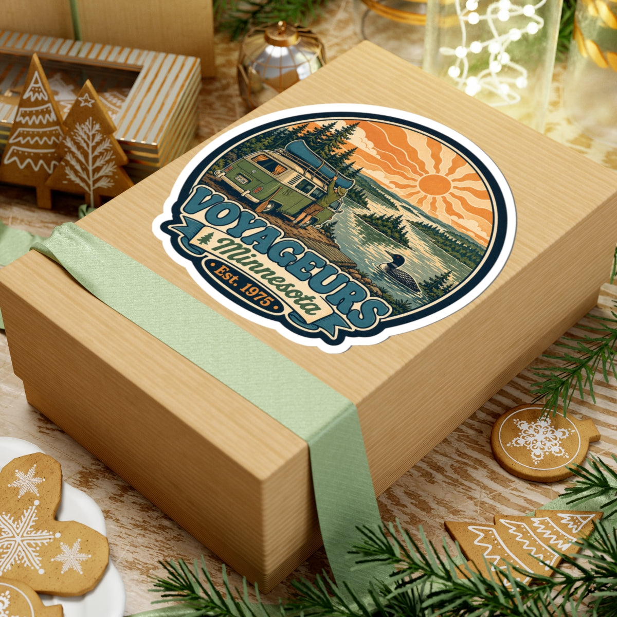 Round die-cut sticker: green camper van and pine landscape with orange sun over lake; Est. 1975
