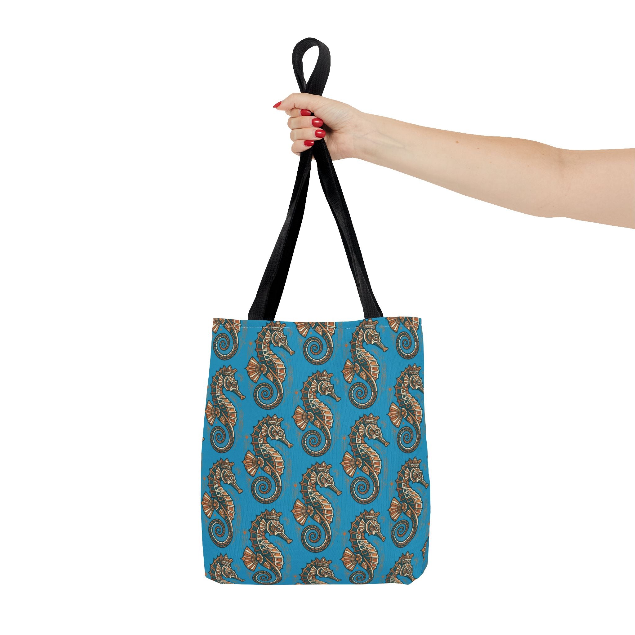 Ocean blue tote bag with steampunk seahorse all-over pattern and black handles, held up